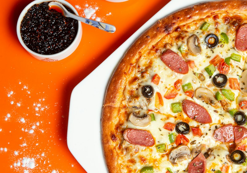 Pizza com queijo e manjericão, ilustrando os sabores tradicionais